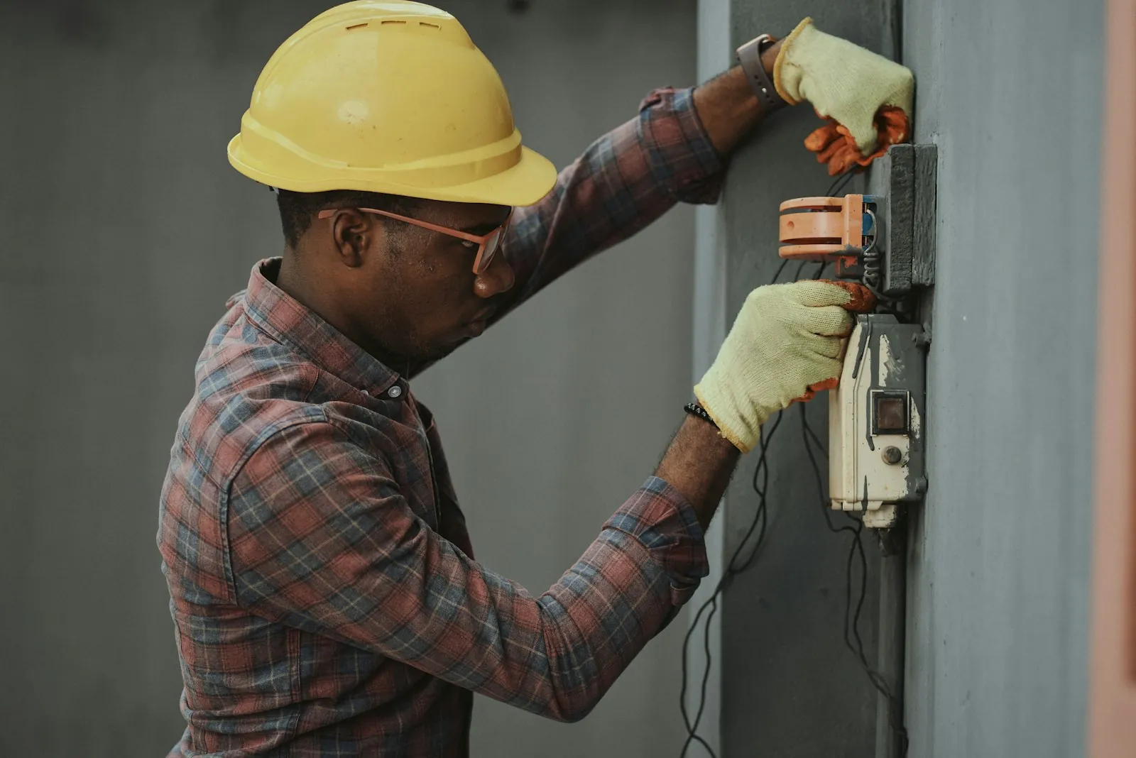African industrial worker at mechanical panel